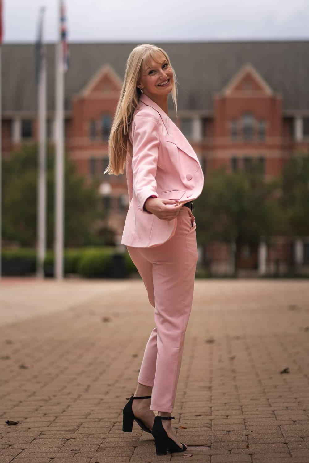 Image 1 of 2 Female student in suit walking outside